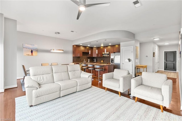 living room featuring ceiling fan and light hardwood / wood-style floors