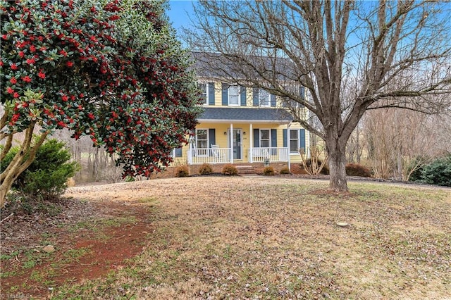 colonial house featuring a porch and a front lawn