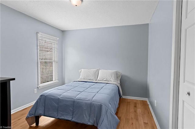 bedroom with hardwood / wood-style flooring and a textured ceiling