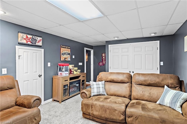 carpeted living room featuring a drop ceiling