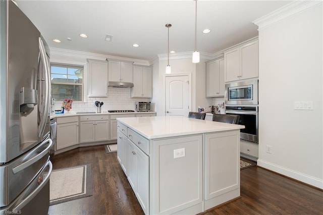 6006 Tanoak Ct, Stokesdale, NC 27357 - kitchen with stainless steel appliances, dark wood-type flooring, light countertops, under cabinet range hood, and crown molding