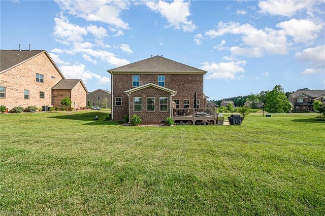 6006 Tanoak Ct, Stokesdale, NC 27357 - rear view of house featuring brick siding, a lawn, and a deck