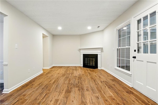 3985 Valley Ct Unit B, Winston-Salem, NC 27106 - unfurnished living room with wood finished floors, a glass covered fireplace, baseboards, recessed lighting, and a textured ceiling