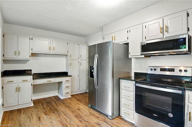 3985 Valley Ct Unit B, Winston-Salem, NC 27106 - kitchen featuring stainless steel appliances, light wood-style flooring, a textured ceiling, white cabinets, and built in study area