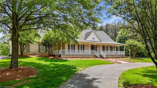 country-style home with a porch, a front lawn, and brick siding