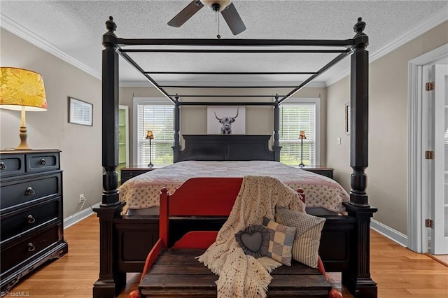 bedroom with light wood finished floors, multiple windows, crown molding, baseboards, and a textured ceiling