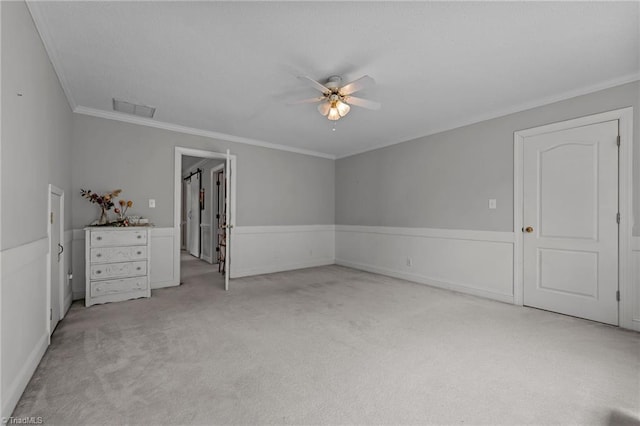 unfurnished bedroom featuring light carpet, crown molding, a ceiling fan, and baseboards