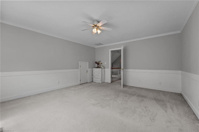 unfurnished room with ceiling fan, carpet flooring, crown molding, and baseboards