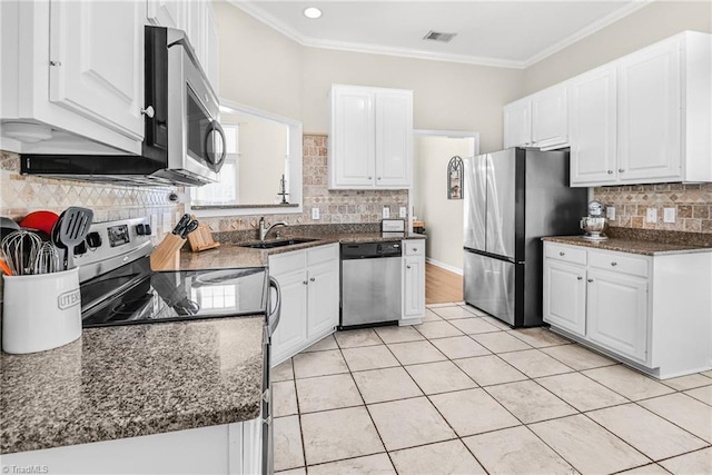 kitchen with a sink, visible vents, appliances with stainless steel finishes, and white cabinets