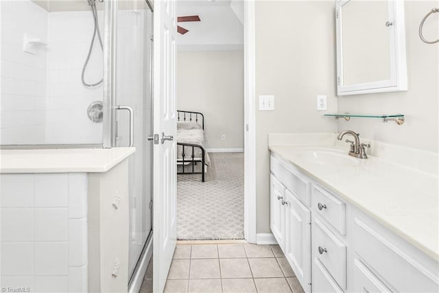 ensuite bathroom with tile patterned floors, a stall shower, ensuite bath, baseboards, and vanity