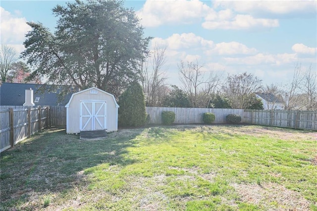 view of yard featuring a storage shed, an outbuilding, and a fenced backyard