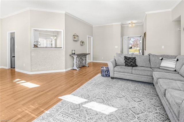 living room with baseboards, wood finished floors, a chandelier, and ornamental molding