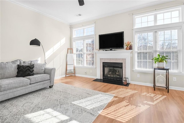 living room featuring crown molding, wood finished floors, visible vents, and baseboards