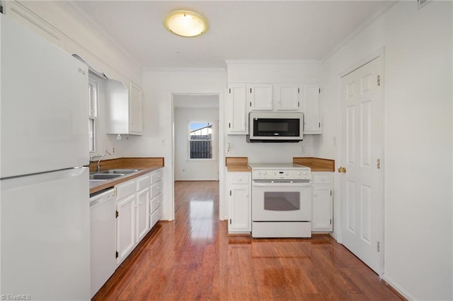 kitchen with dark hardwood / wood-style floors, sink, white cabinets, ornamental molding, and white appliances