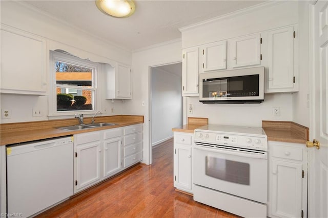 kitchen with white cabinetry, sink, white appliances, and light hardwood / wood-style flooring