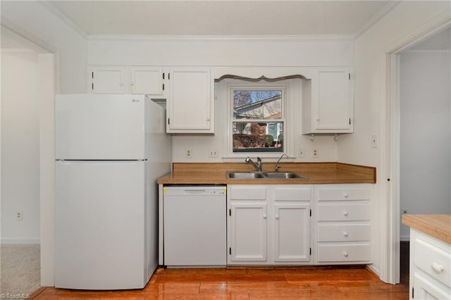 kitchen featuring sink, white cabinets, ornamental molding, white appliances, and light hardwood / wood-style flooring