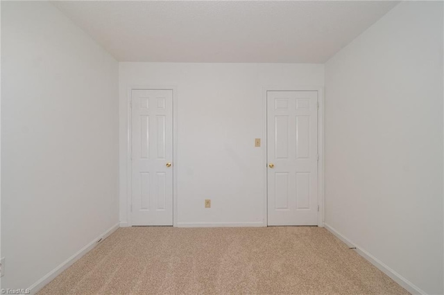 spare room featuring light colored carpet