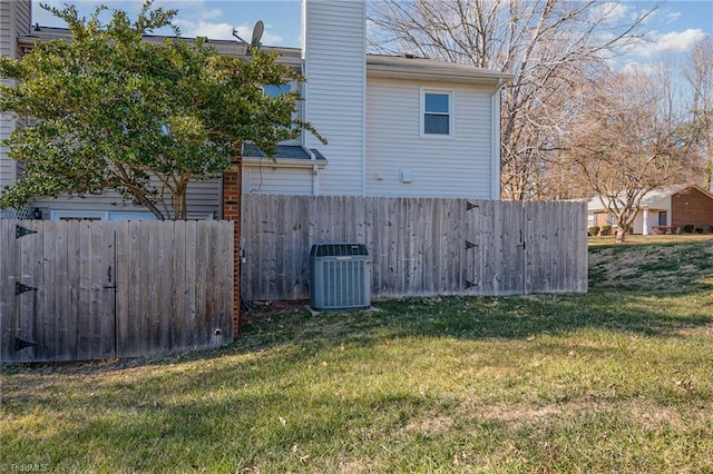 view of side of property featuring central air condition unit and a lawn