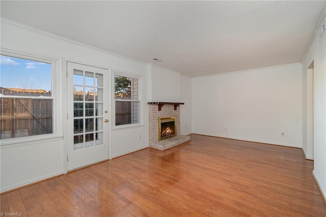 unfurnished living room featuring crown molding, a fireplace, and light hardwood / wood-style flooring