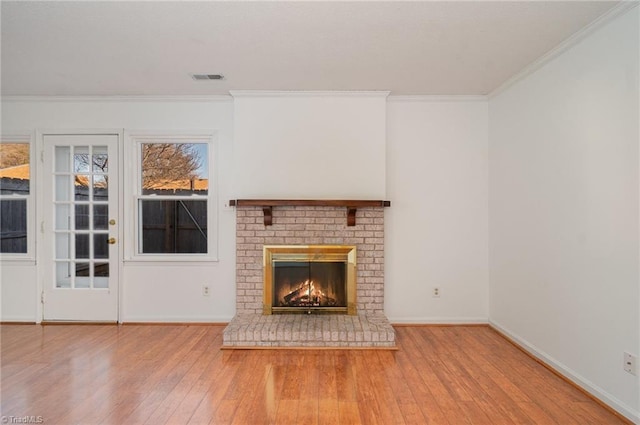 unfurnished living room with crown molding, a brick fireplace, and hardwood / wood-style floors