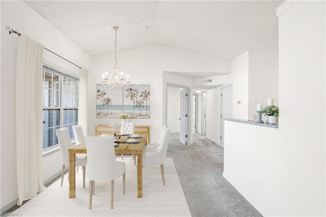 carpeted dining room with vaulted ceiling and a notable chandelier