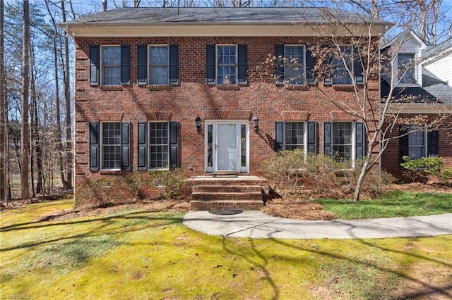 view of front facade with a front yard and brick siding