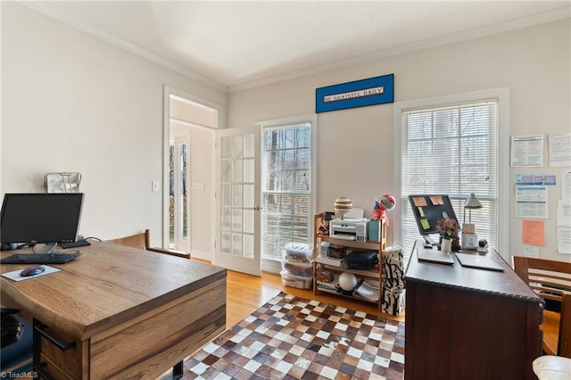 home office with wood finished floors, french doors, plenty of natural light, and ornamental molding