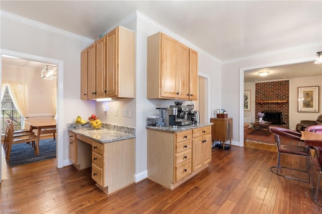 kitchen featuring light brown cabinets, open floor plan, a fireplace, crown molding, and dark wood-style flooring