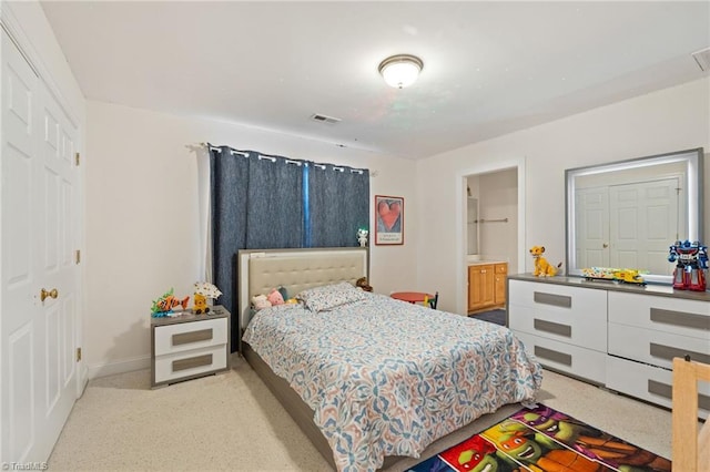 bedroom featuring visible vents, ensuite bathroom, and baseboards