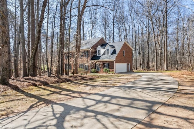 view of front facade with concrete driveway, a garage, and brick siding