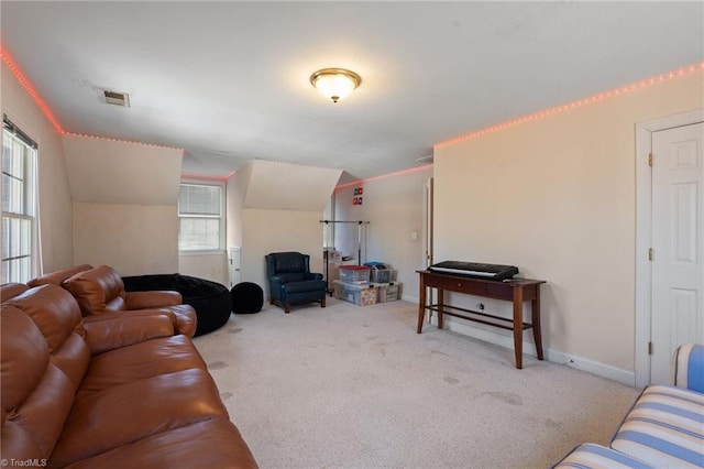 living area with a wealth of natural light, visible vents, lofted ceiling, and carpet