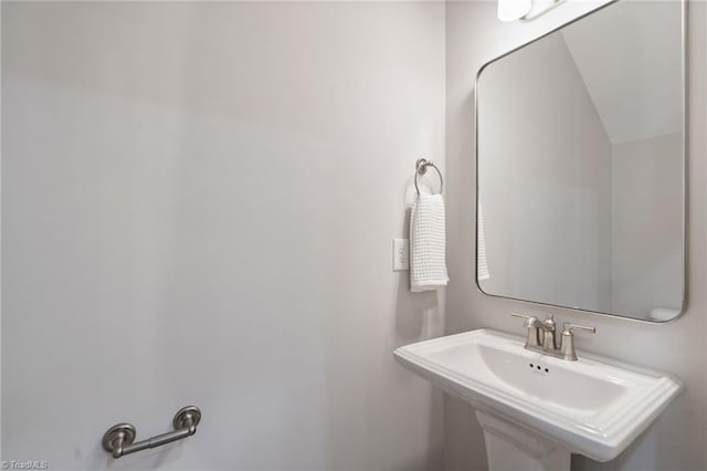 bathroom featuring lofted ceiling and a sink