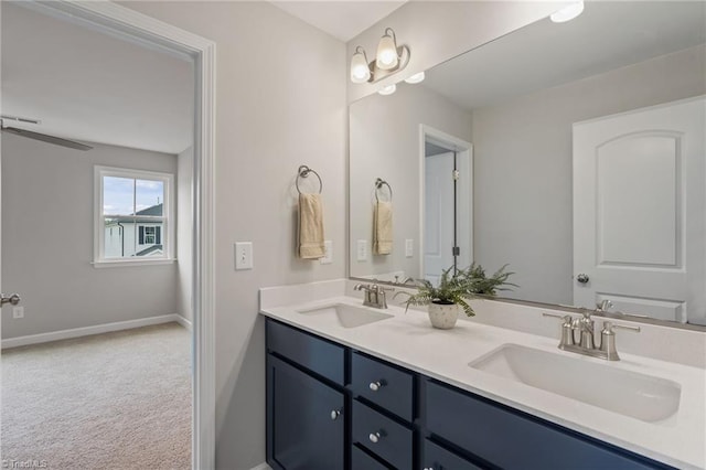 bathroom featuring a sink, baseboards, and double vanity