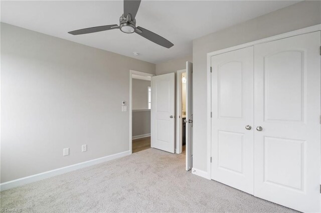 unfurnished bedroom with ceiling fan, carpet floors, a closet, and baseboards