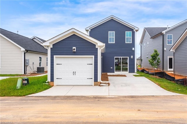 view of front of house featuring driveway, central AC unit, and an attached garage