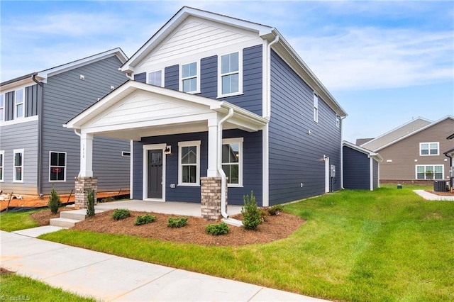 view of front of house featuring covered porch, a front lawn, and central AC