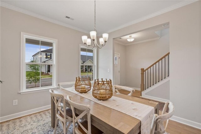 dining area with crown molding, wood finished floors, visible vents, and baseboards