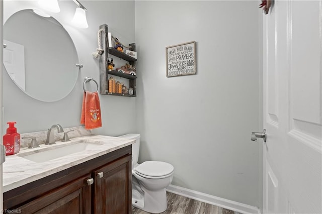 bathroom featuring vanity, baseboards, toilet, and wood finished floors
