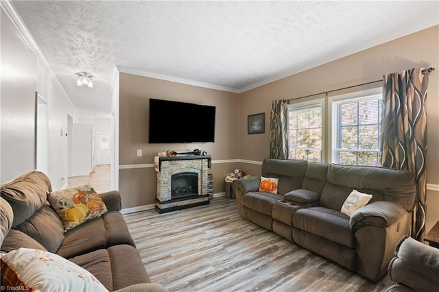 living room featuring light hardwood / wood-style floors, crown molding, a textured ceiling, and a fireplace