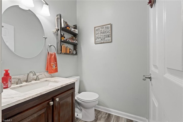 bathroom with vanity, toilet, and hardwood / wood-style floors