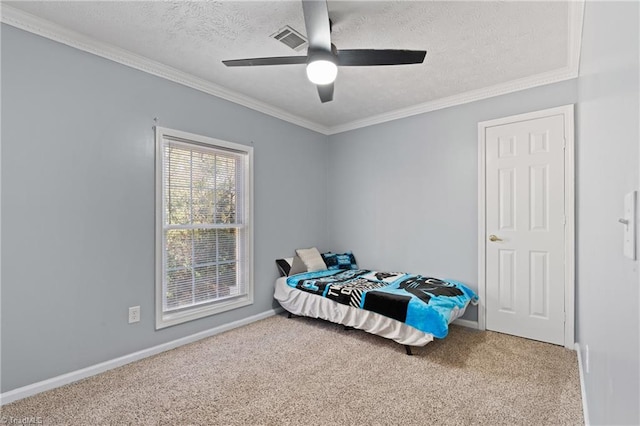 carpeted bedroom featuring visible vents, a textured ceiling, crown molding, and baseboards