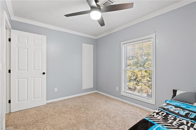 bedroom featuring baseboards, ornamental molding, carpet, and a ceiling fan