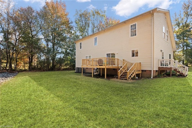 rear view of house featuring a yard, a wooden deck, and stairs