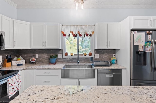 kitchen with crown molding, white cabinetry, appliances with stainless steel finishes, and tasteful backsplash