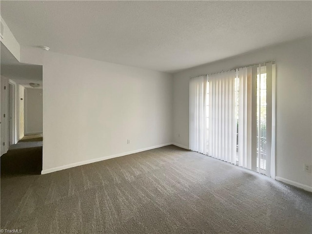 carpeted spare room featuring a textured ceiling