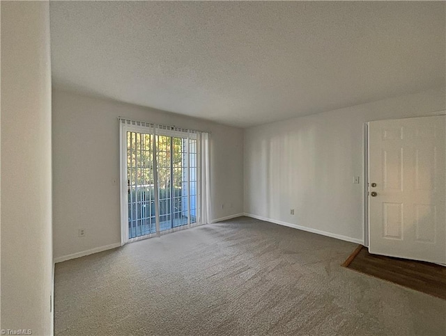 carpeted empty room with a textured ceiling