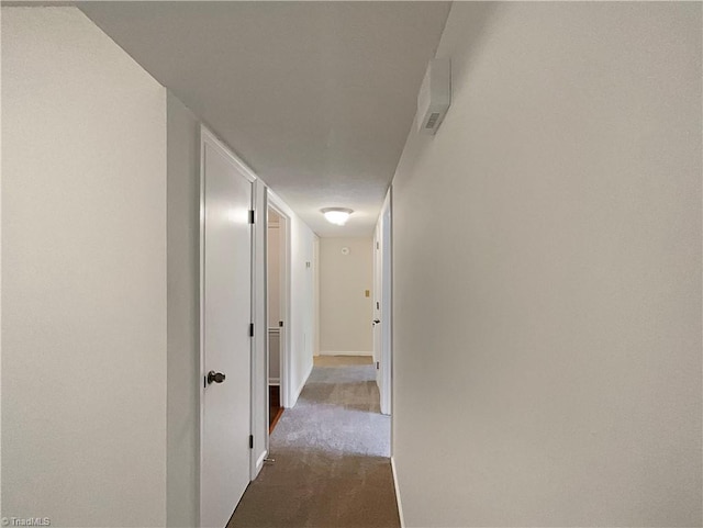 hallway featuring dark colored carpet