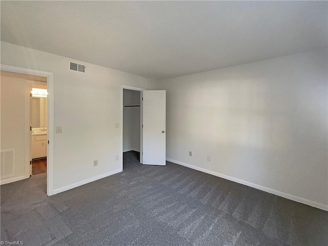 unfurnished bedroom with dark carpet