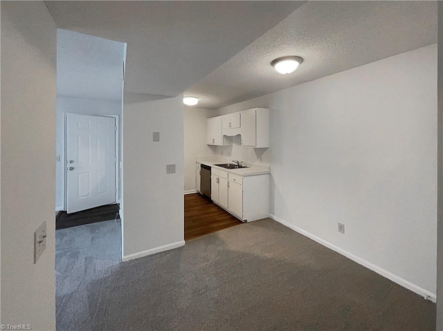 kitchen with sink, stainless steel dishwasher, dark carpet, and white cabinets