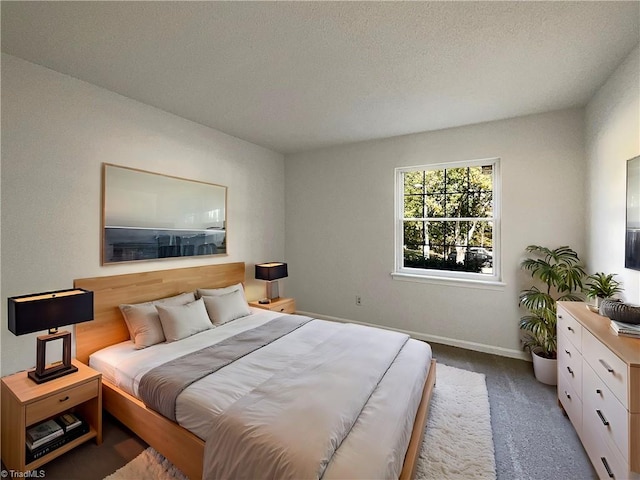 bedroom featuring a textured ceiling and carpet flooring